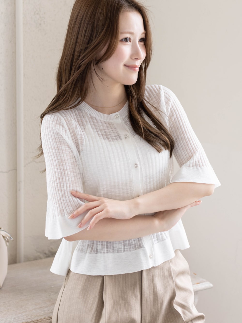 ベージュ系のスラックス、ホワイト系のパンプス、ホワイト系のカーディガン/ボレロを着用したレディースの春コーディネートの5枚目の写真