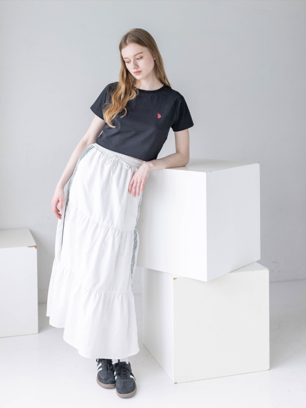 ブラック系のスニーカー、ホワイト系のスカート、ブラック系のTシャツ/カットソーを着用したレディースの夏コーディネートの4枚目の写真