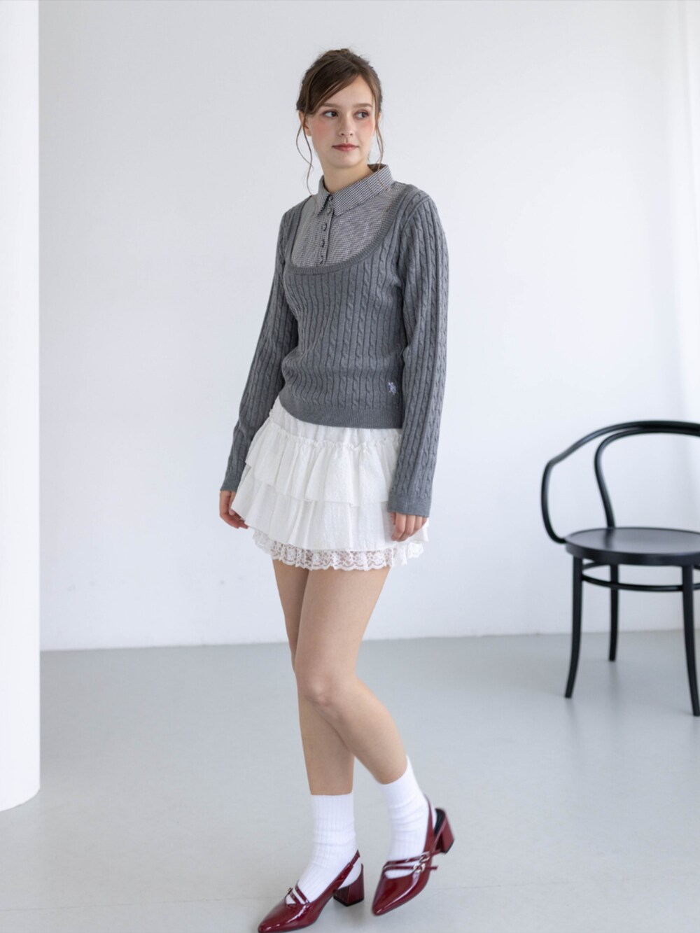 レッド系のパンプス、ホワイト系のスカート、グレー系のニット/セーターを着用したレディースの秋コーディネートの3枚目の写真
