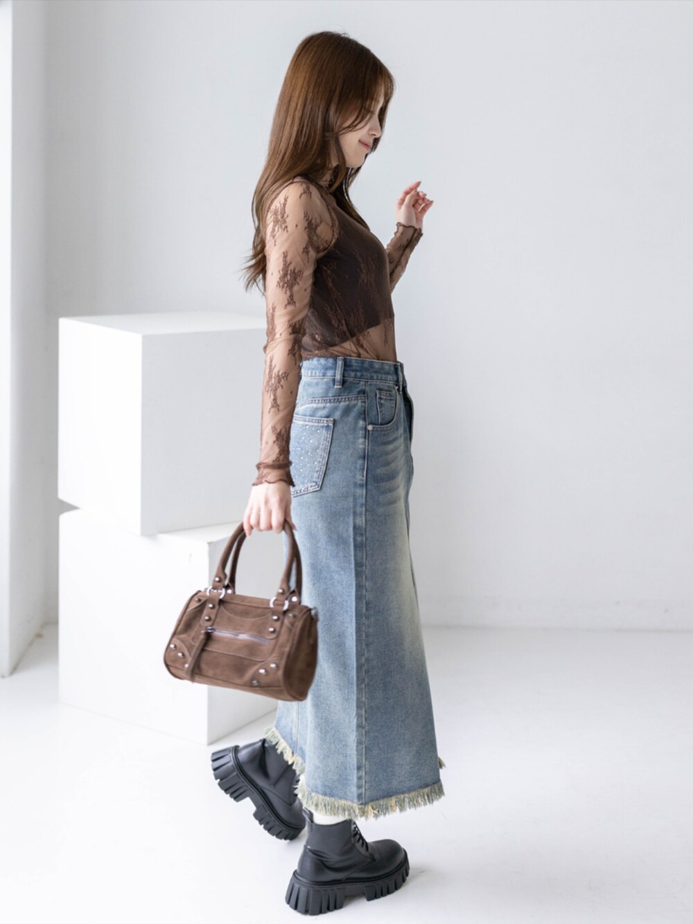 ブラック系のブーツ、ブルー系のデニムスカート、ブラウン系のTシャツ/カットソーを着用したレディースの夏コーディネートの3枚目の写真