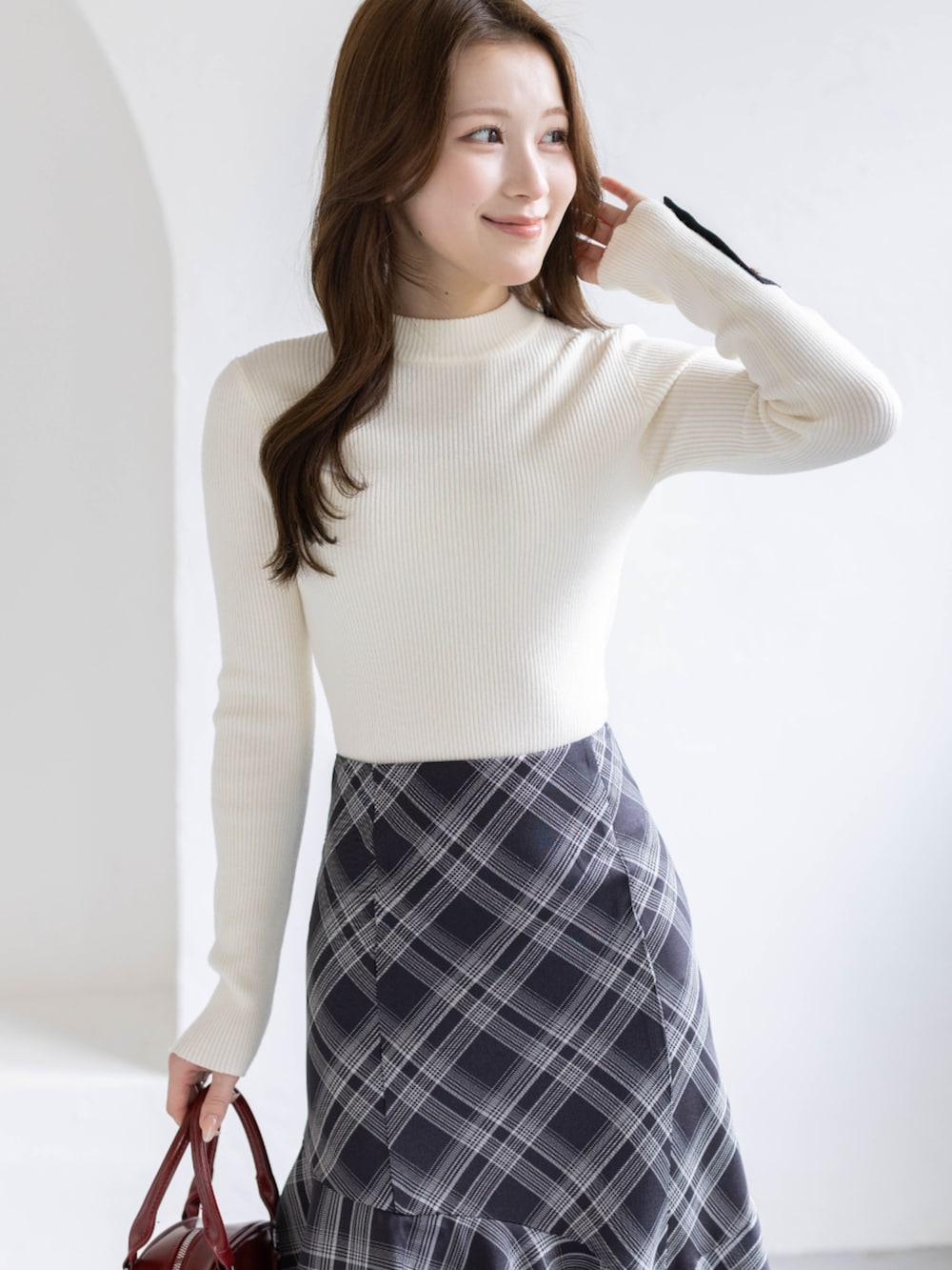 ブラック系のパンプス、ホワイト系のニット/セーター、ブラック系のスカートを着用したレディースの春コーディネートの5枚目の写真