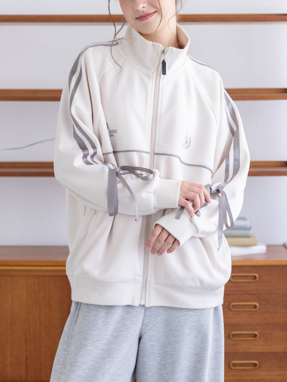 ゴールド系のスニーカー、グレー系のスウェットパンツ、ホワイト系のTシャツ/カットソーを着用したレディースの秋コーディネートの5枚目の写真