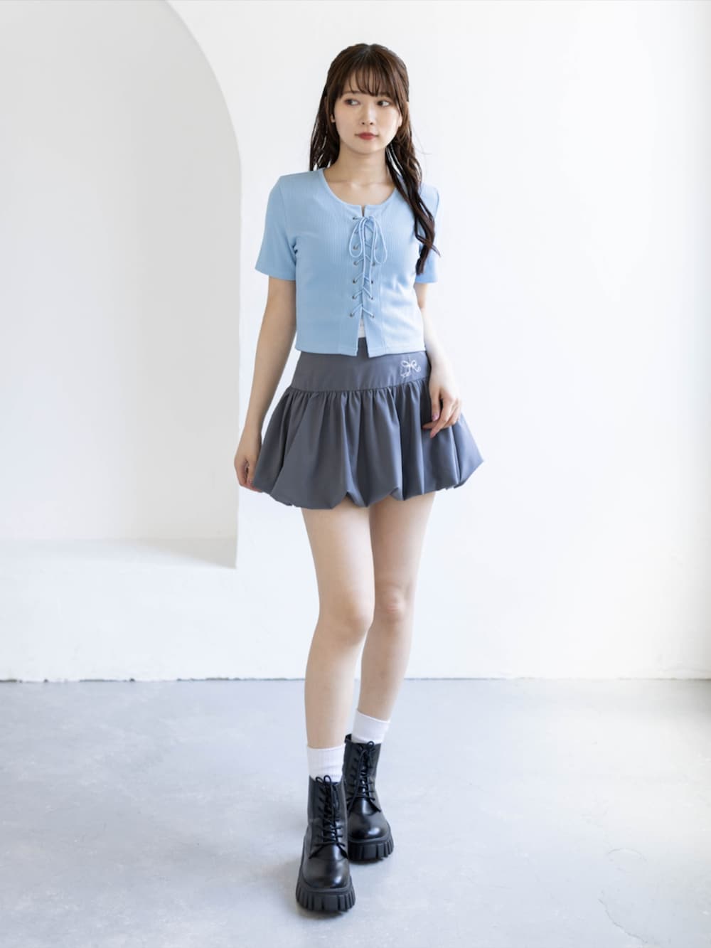 ブラック系のブーツ、グレー系のスカート、ブルー系のTシャツ/カットソーを着用したレディースの夏コーディネートの2枚目の写真