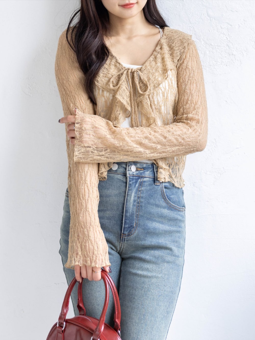 レッド系のパンプス、ブルー系のデニムパンツ、ベージュ系のTシャツ/カットソーを着用したレディースの春コーディネートの4枚目の写真