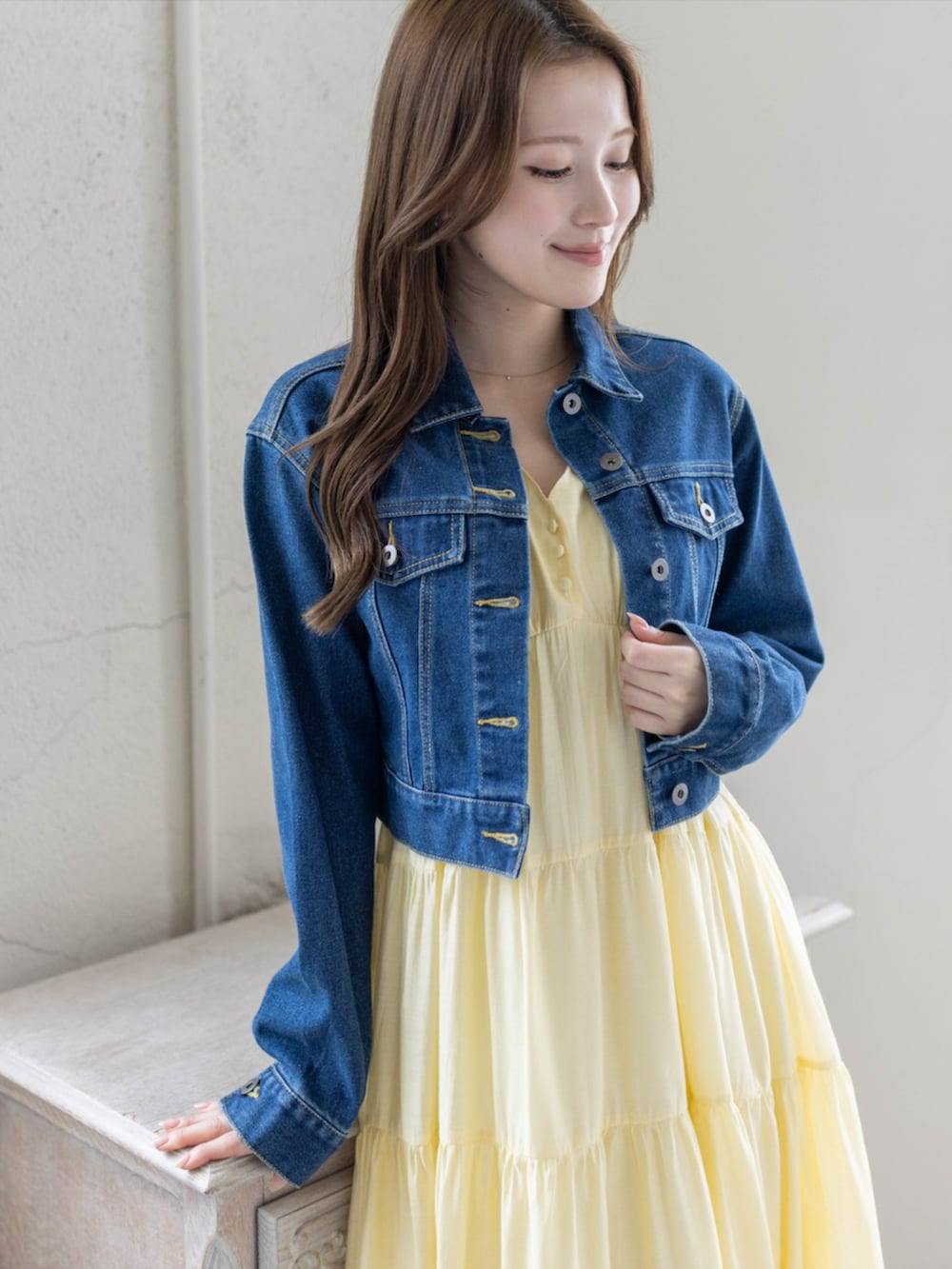 シルバー系のパンプス、ブルー系のデニムジャケット、イエロー系のワンピースを着用したレディースの春コーディネートの5枚目の写真