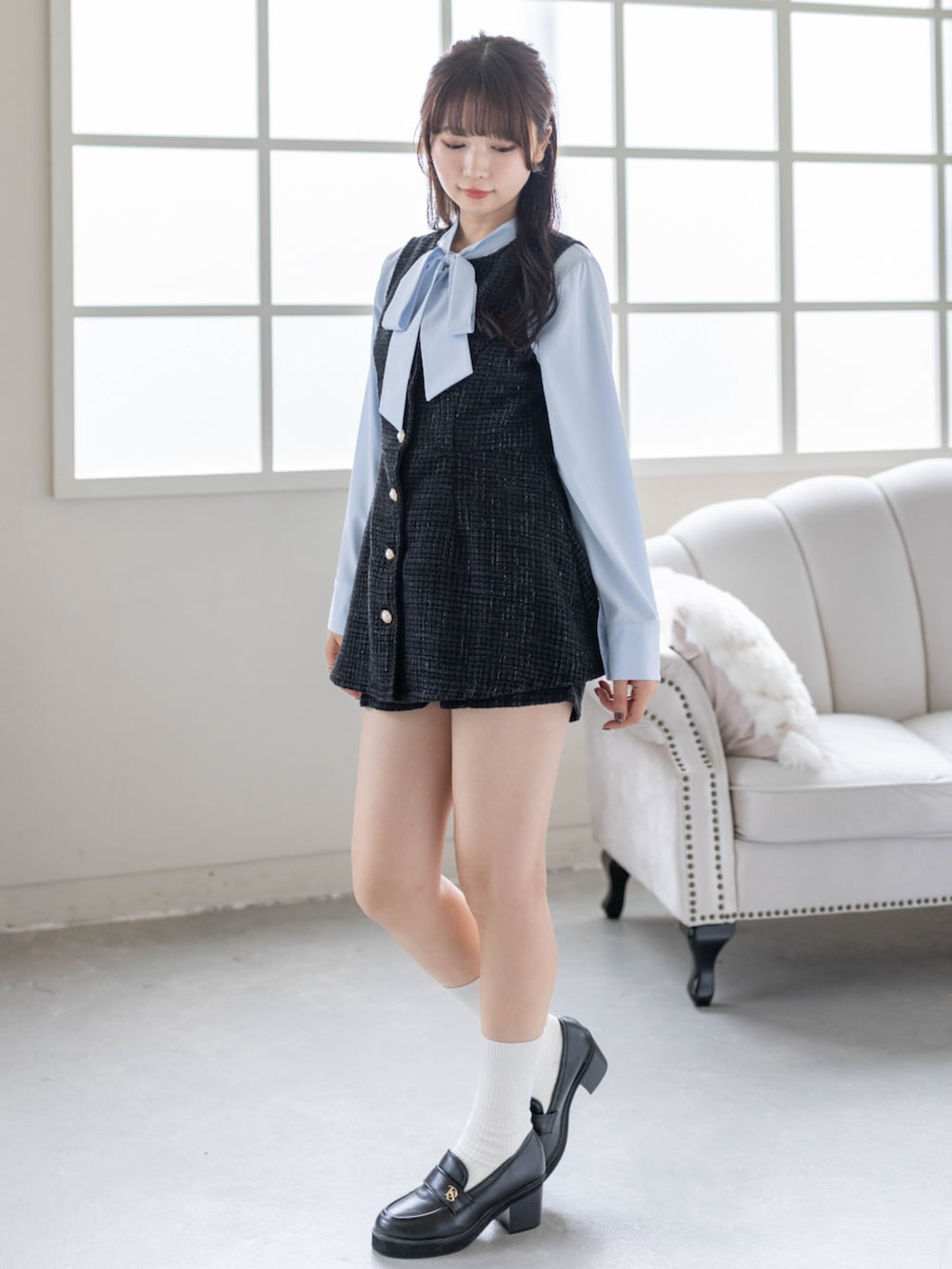 ブラック系のローファー、ブラック系のチュニック、ブルー系のシャツ/ブラウスを着用したレディースの春コーディネートの2枚目の写真