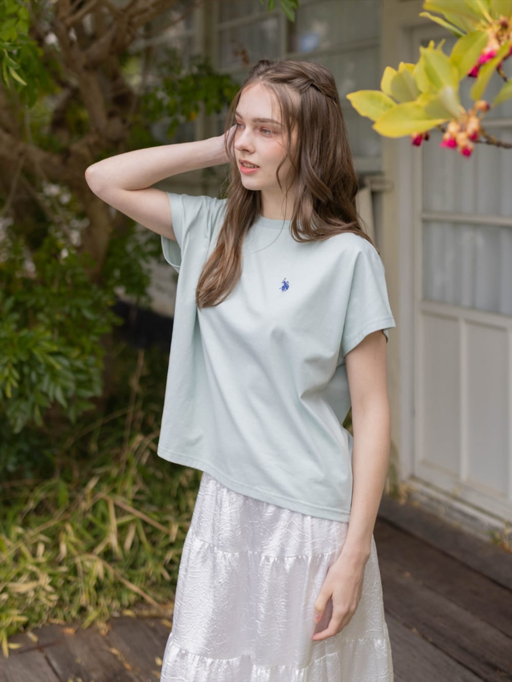 ホワイト系のスカート、グリーン系のTシャツ/カットソーを着用したレディースの夏コーディネートの3枚目の写真