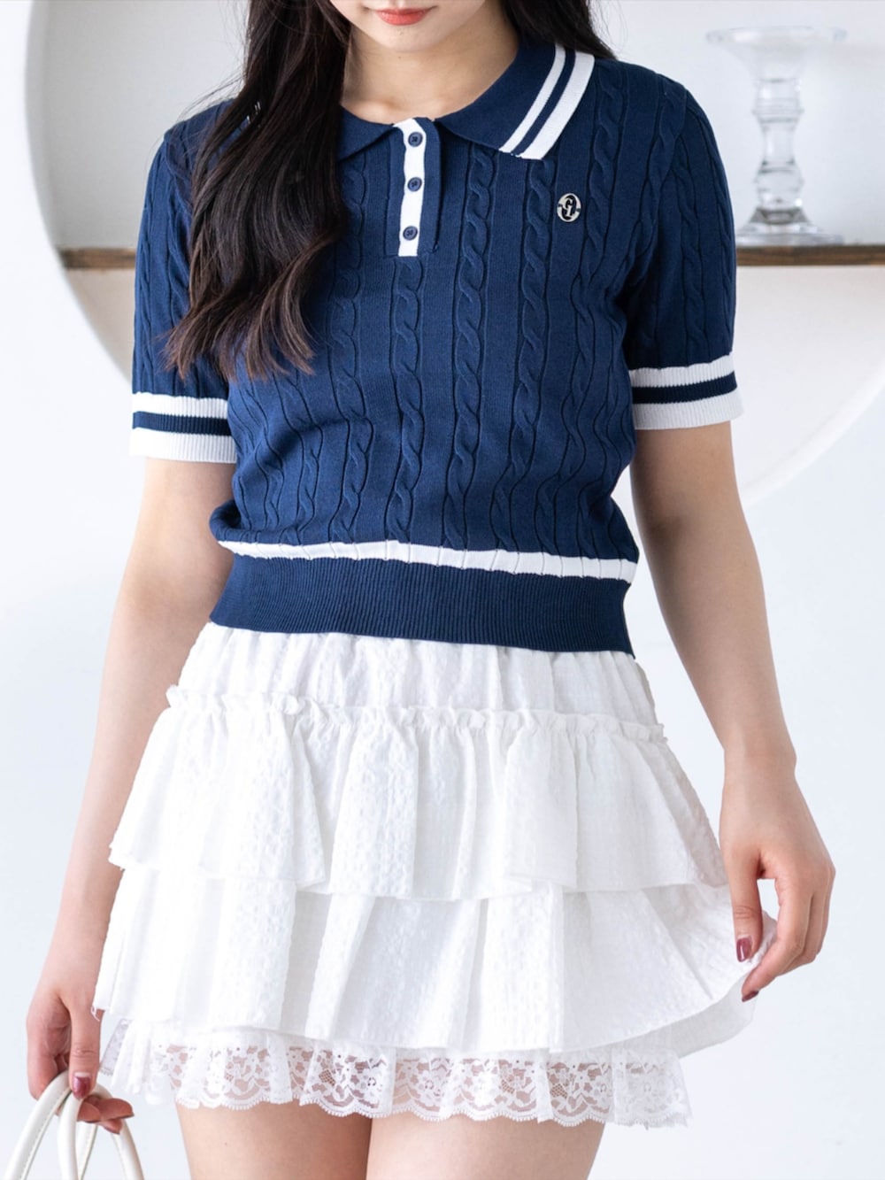 ホワイト系のハンドバッグ、ホワイト系のスカート、ブラック系のローファーを着用したレディースの春コーディネートの5枚目の写真