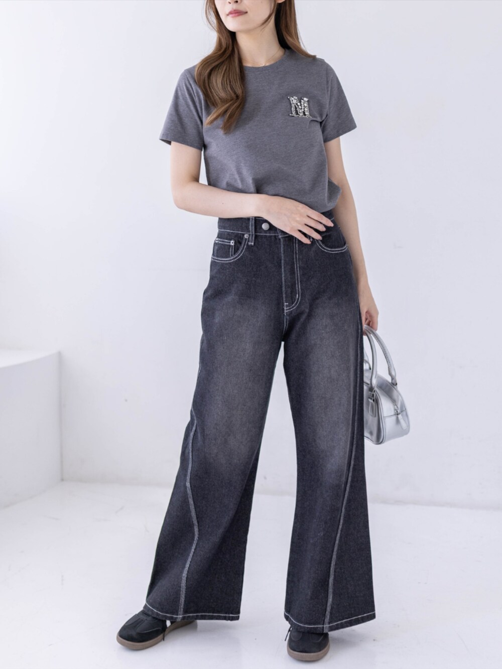 ブラック系のスニーカー、ブラック系のデニムパンツ、グレー系のTシャツ/カットソーを着用したレディースの春コーディネートの4枚目の写真