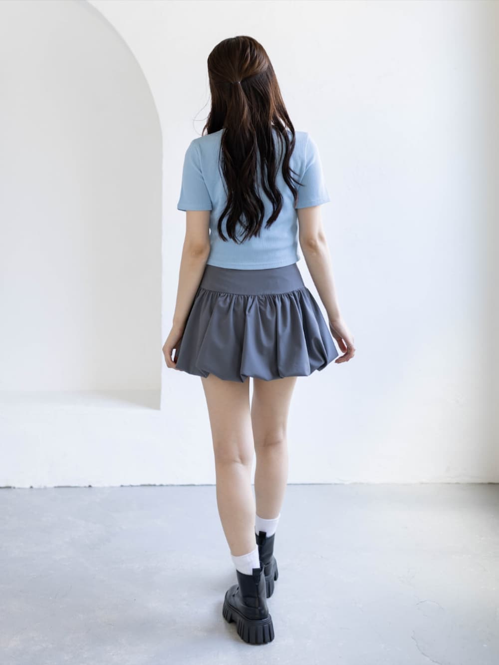 ブラック系のブーツ、グレー系のスカート、ブルー系のTシャツ/カットソーを着用したレディースの夏コーディネートの3枚目の写真