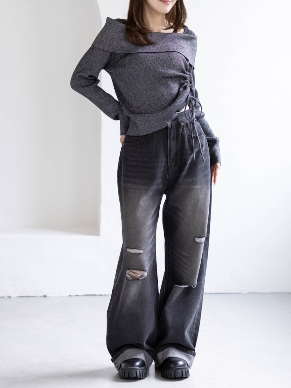 ブラック系のデニムパンツ、ブラック系のブーツ、ブラック系のニット/セーターを着用したレディースの秋コーディネートの4枚目の写真