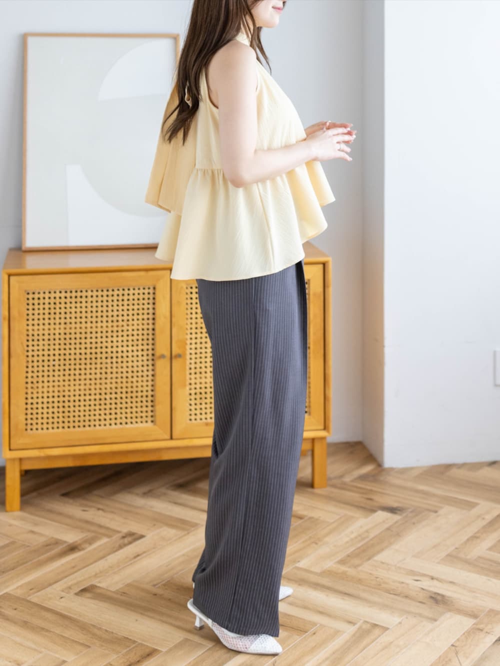 ホワイト系のパンプス、グレー系のスラックス、イエロー系のシャツ/ブラウスを着用したレディースの夏コーディネートの3枚目の写真
