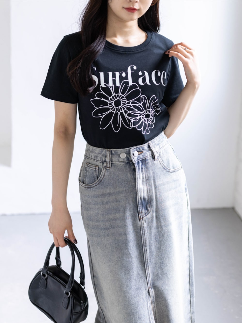 ホワイト系のスニーカー、ブルー系のスカート、ブラック系のTシャツ/カットソーを着用したレディースの春コーディネートの8枚目の写真