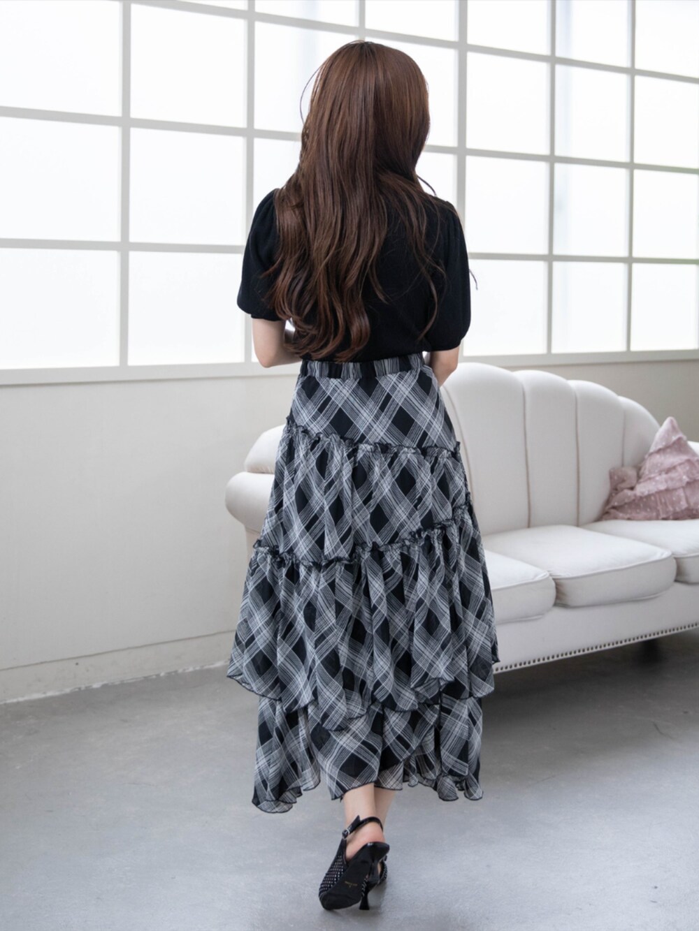 ブラック系のハンドバッグ、ブラック系のパンプス、ブラック系のニット/セーターを着用したレディースの夏コーディネートの2枚目の写真