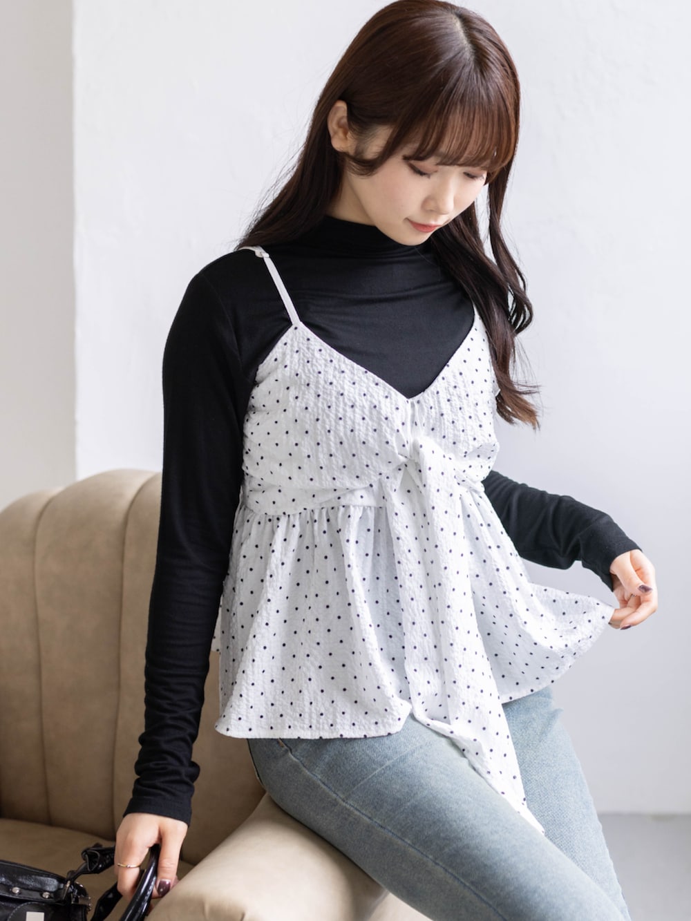 ブルー系のデニムパンツ、ブラック系のパンプス、ホワイト系のキャミソールを着用したレディースの春コーディネートの3枚目の写真