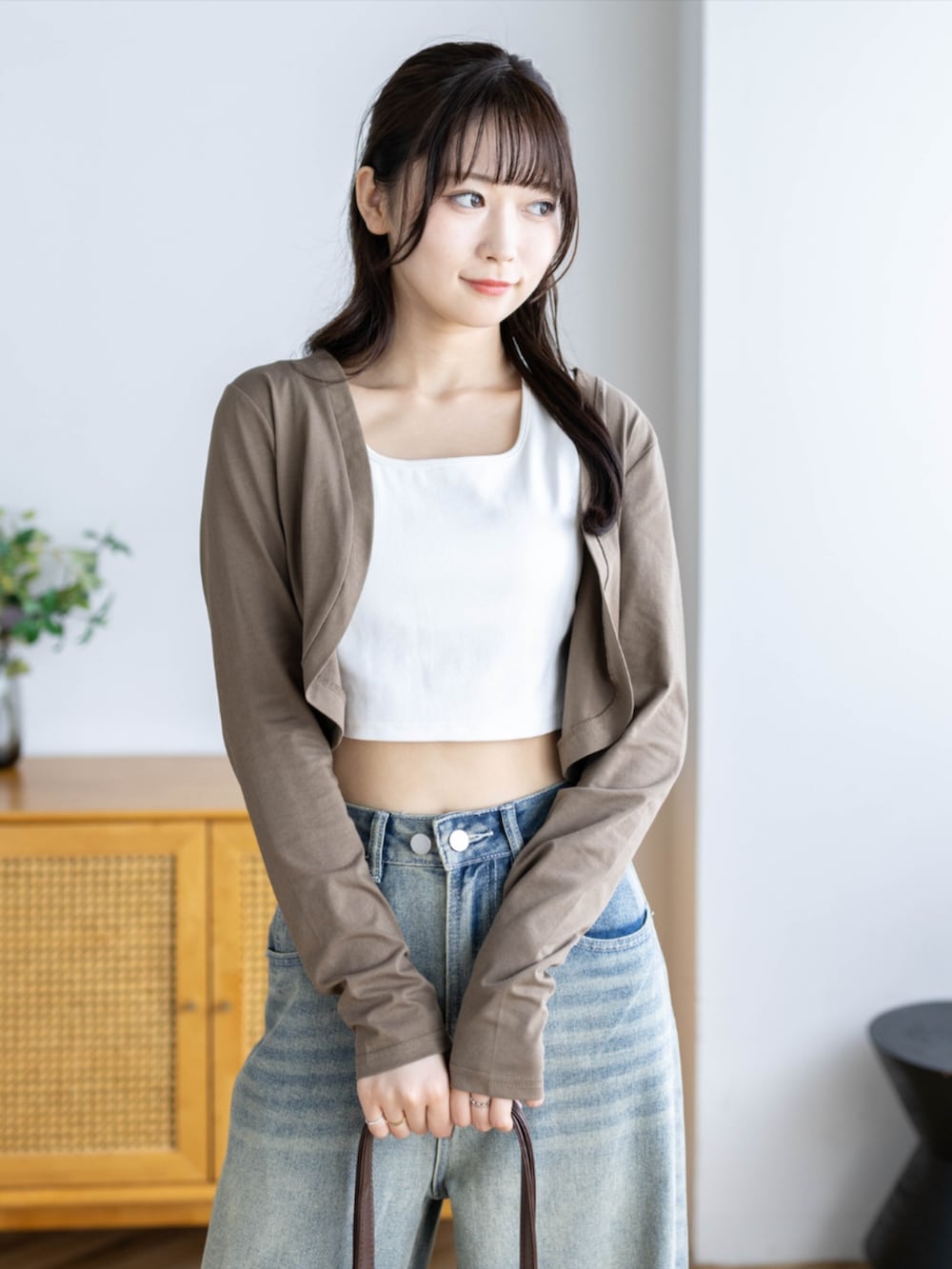 ブラウン系のショルダーバッグ、ブルー系のデニムパンツ、ブラウン系のカーディガン/ボレロを着用したレディースの夏コーディネートの6枚目の写真
