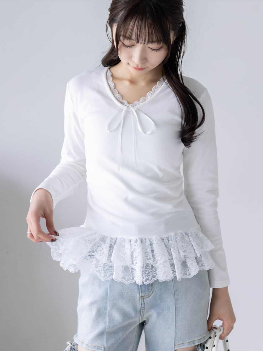 ホワイト系のパンプス、ブルー系のデニムパンツ、ホワイト系のボストンバッグを着用したレディースの夏コーディネートの4枚目の写真