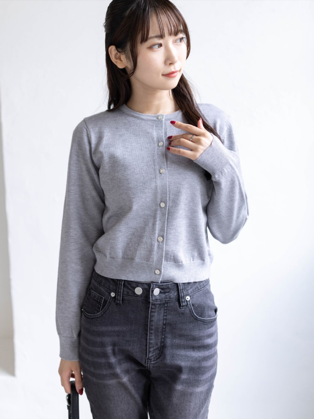 ブラック系のデニムパンツ、ブラック系のパンプス、グレー系のニット/セーターを着用したレディースの秋コーディネートの6枚目の写真