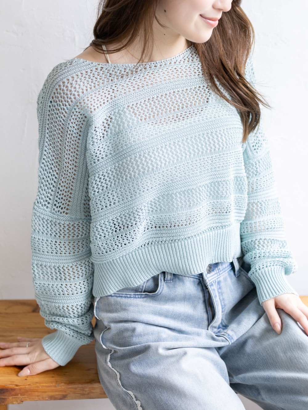 ホワイト系のパンプス、ブルー系のデニムパンツ、グリーン系のニット/セーターを着用したレディースの春コーディネートの5枚目の写真