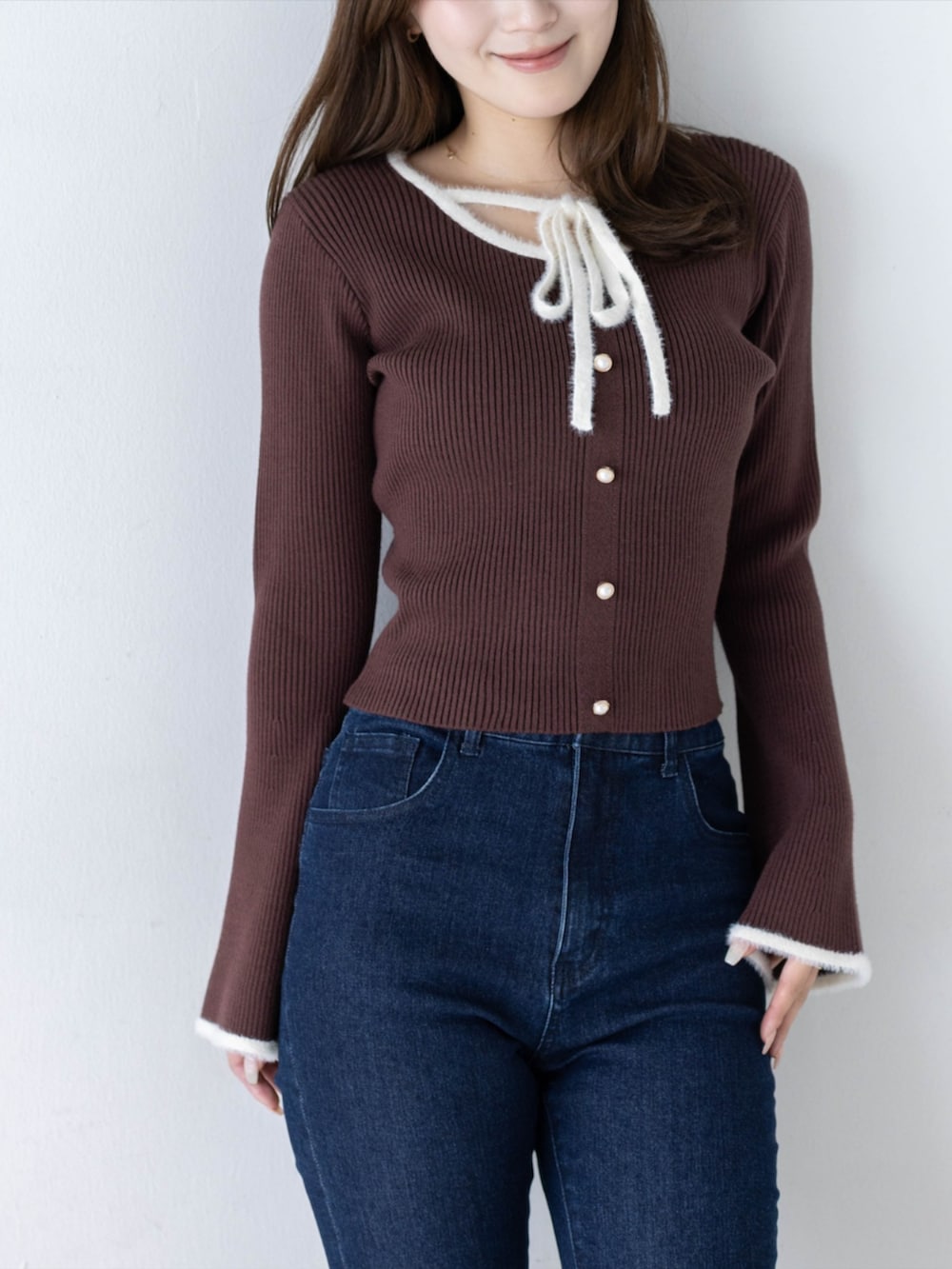 ブルー系のデニムパンツ、ブラック系のパンプス、ブラウン系のニット/セーターを着用したレディースの秋コーディネートの5枚目の写真