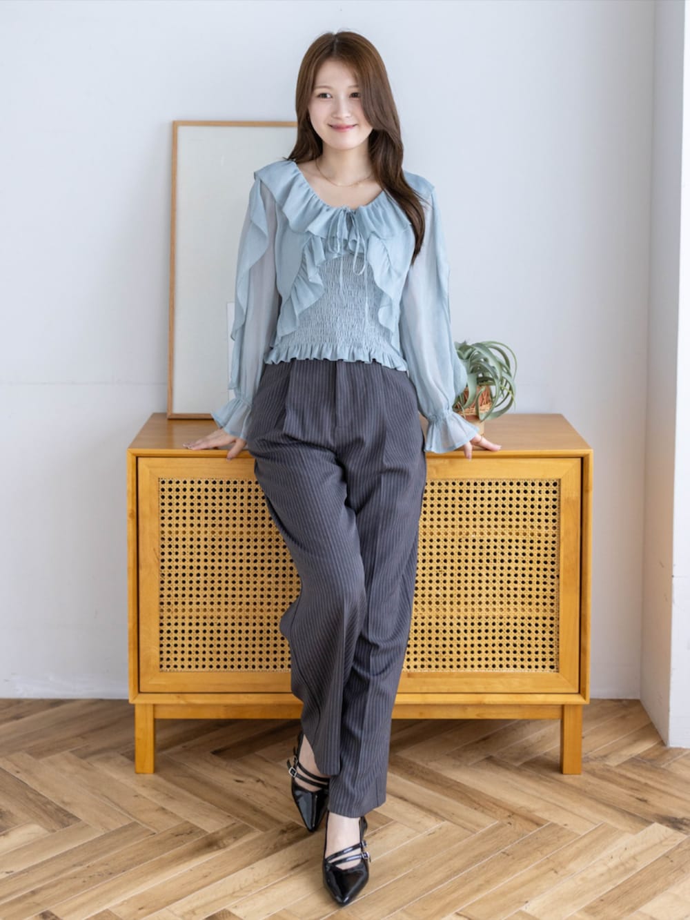 ブラック系のパンプス、グレー系のスラックス、グリーン系のシャツ/ブラウスを着用したレディースの夏コーディネートの2枚目の写真