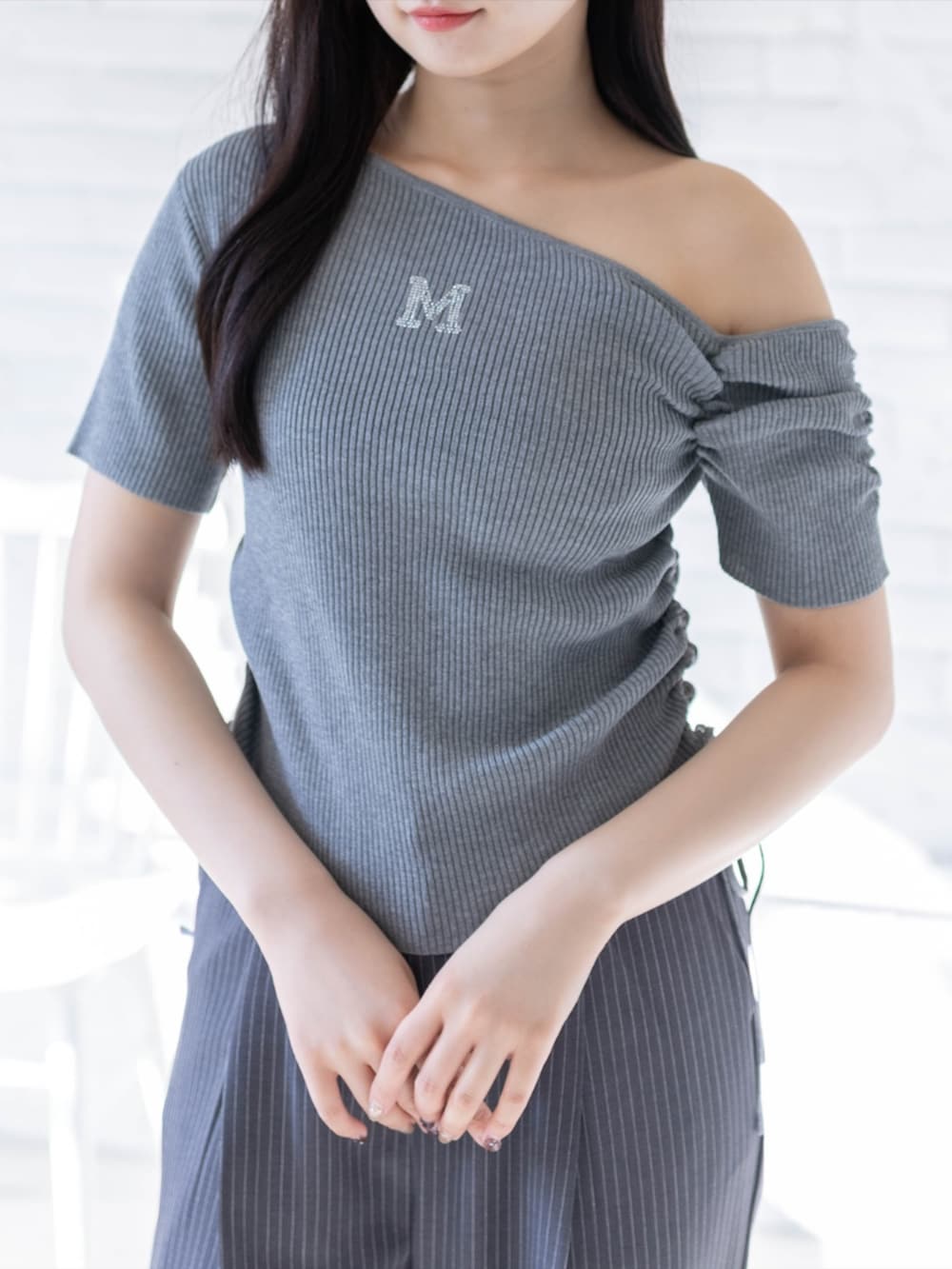 ホワイト系のスニーカー、グレー系のスラックス、グレー系のニット/セーターを着用したレディースの春コーディネートの3枚目の写真