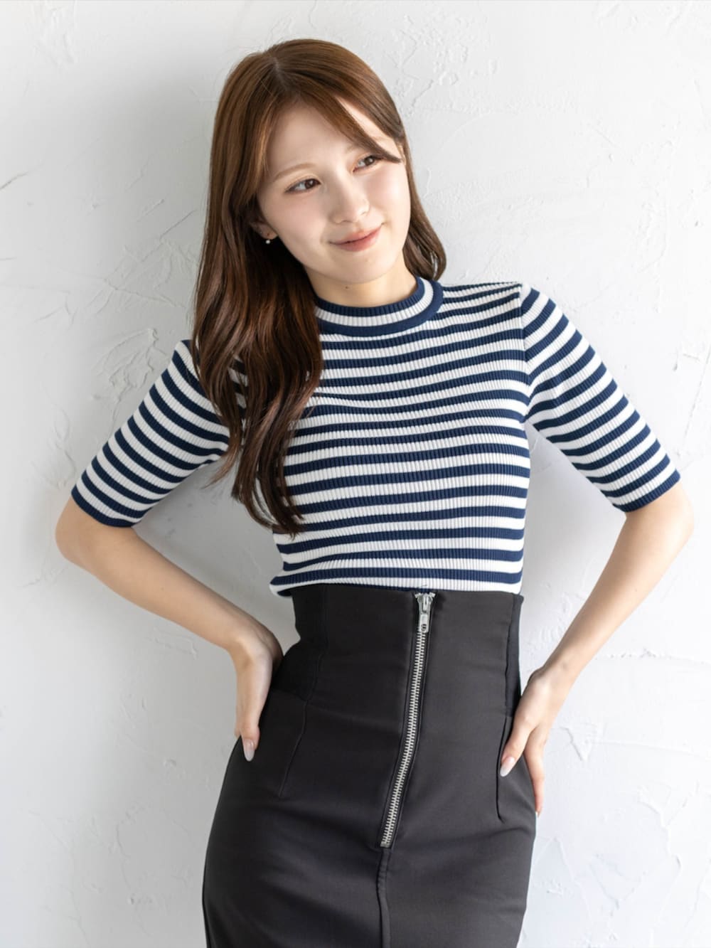 ブラック系のスカート、ブルー系のニット/セーター、ブラック系のパンプスを着用したレディースの夏コーディネートの4枚目の写真