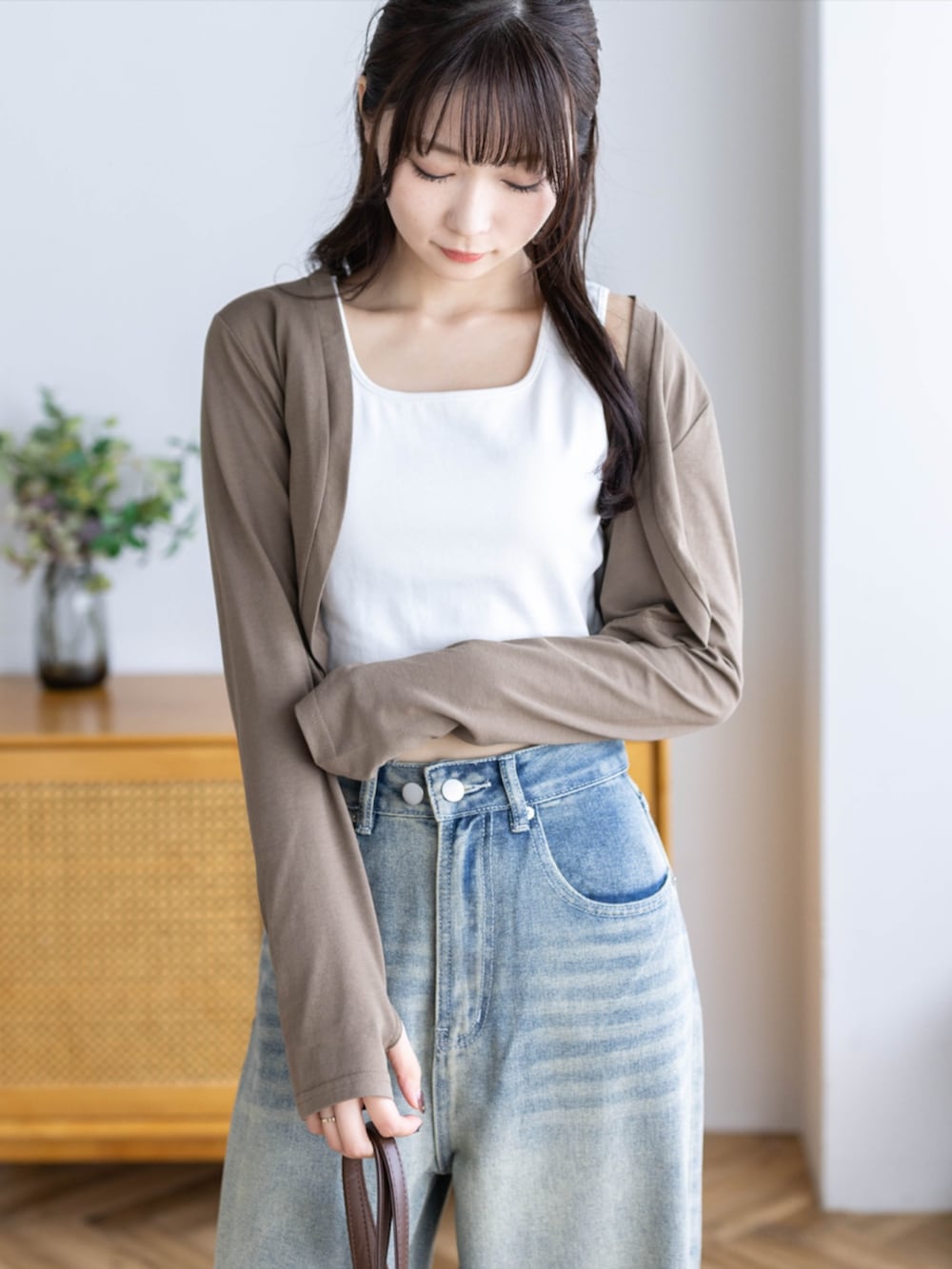 ブラウン系のショルダーバッグ、ブルー系のデニムパンツ、ブラウン系のカーディガン/ボレロを着用したレディースの夏コーディネートの7枚目の写真