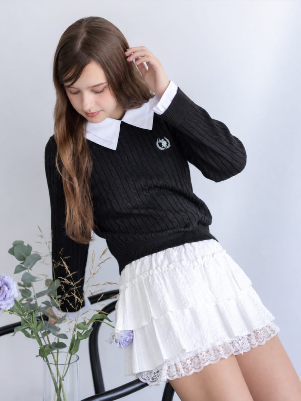 レッド系のパンプス、ホワイト系のスカート、ブラック系のニット/セーターを着用したレディースの秋コーディネートの3枚目の写真