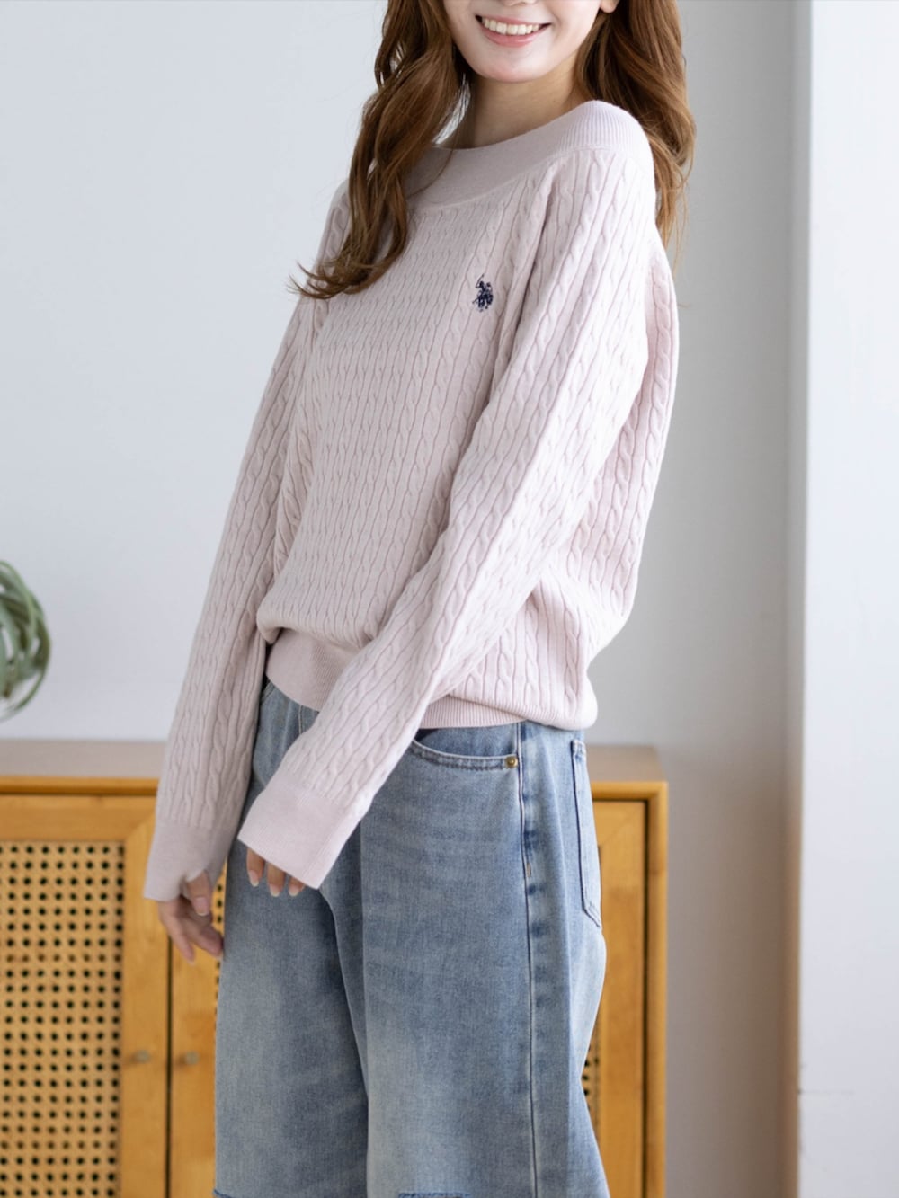 ピンク系のスニーカー、ブルー系のデニムパンツ、ピンク系のニット/セーターを着用したレディースの秋コーディネートの4枚目の写真
