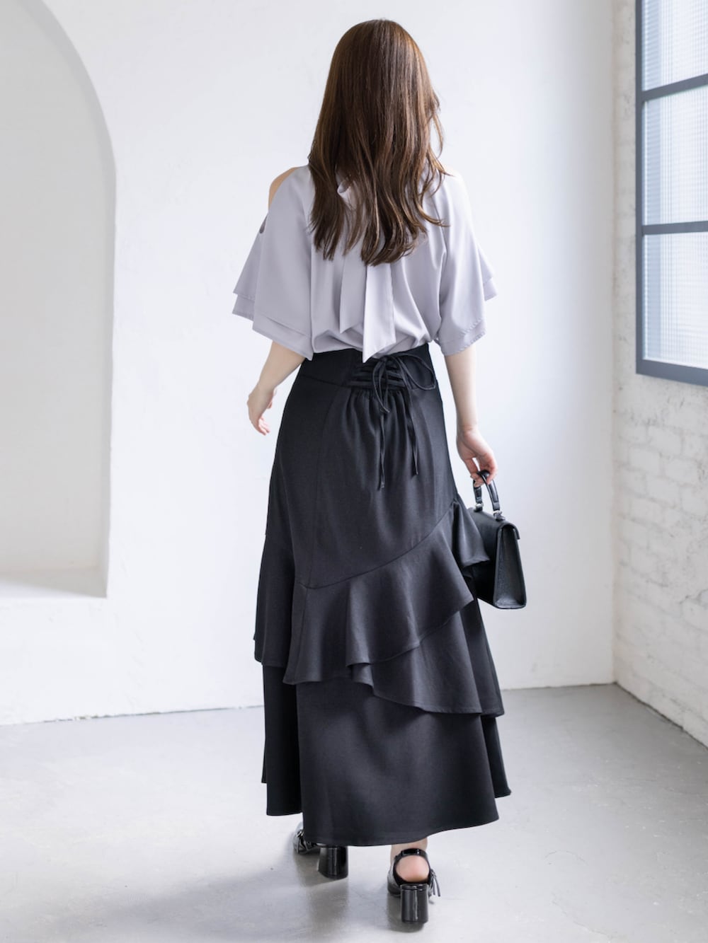 ブラック系のパンプス、グレー系のシャツ/ブラウス、ブラック系のハンドバッグを着用したレディースの春コーディネートの4枚目の写真