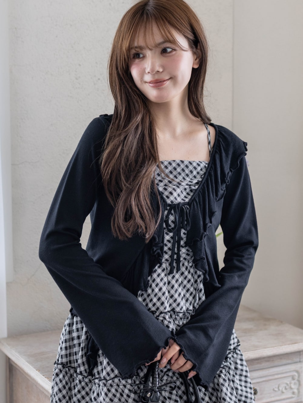 ブラック系のパンプス、ブラック系のハンドバッグ、ブラック系のワンピースを着用したレディースの春コーディネートの4枚目の写真