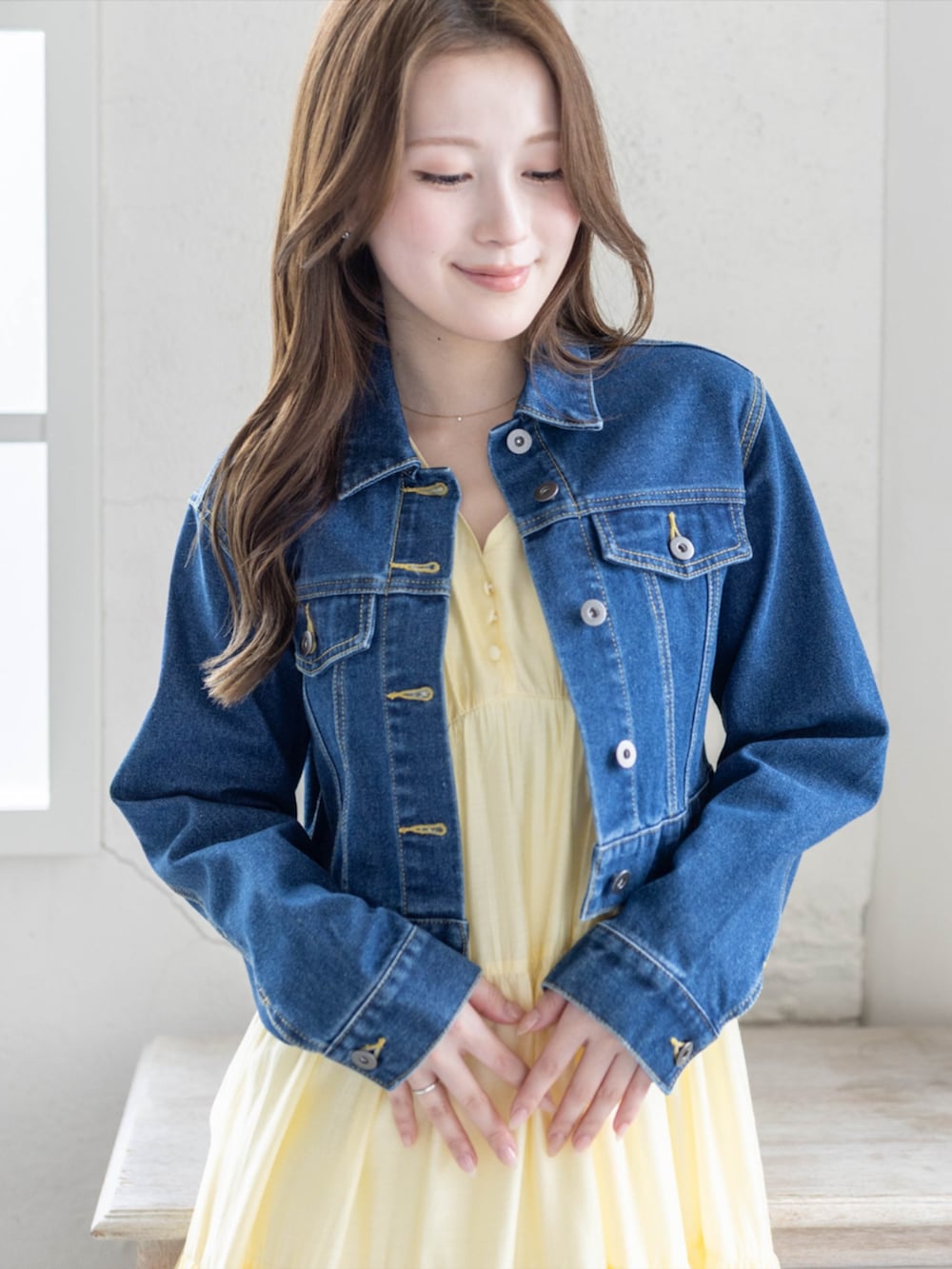 シルバー系のパンプス、ブルー系のデニムジャケット、イエロー系のワンピースを着用したレディースの春コーディネートの3枚目の写真