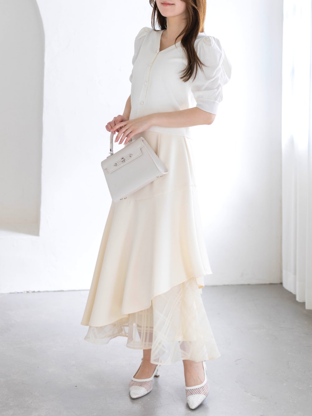 ホワイト系のスカート、ホワイト系のハンドバッグ、ホワイト系のパンプスを着用したレディースの春コーディネートの4枚目の写真
