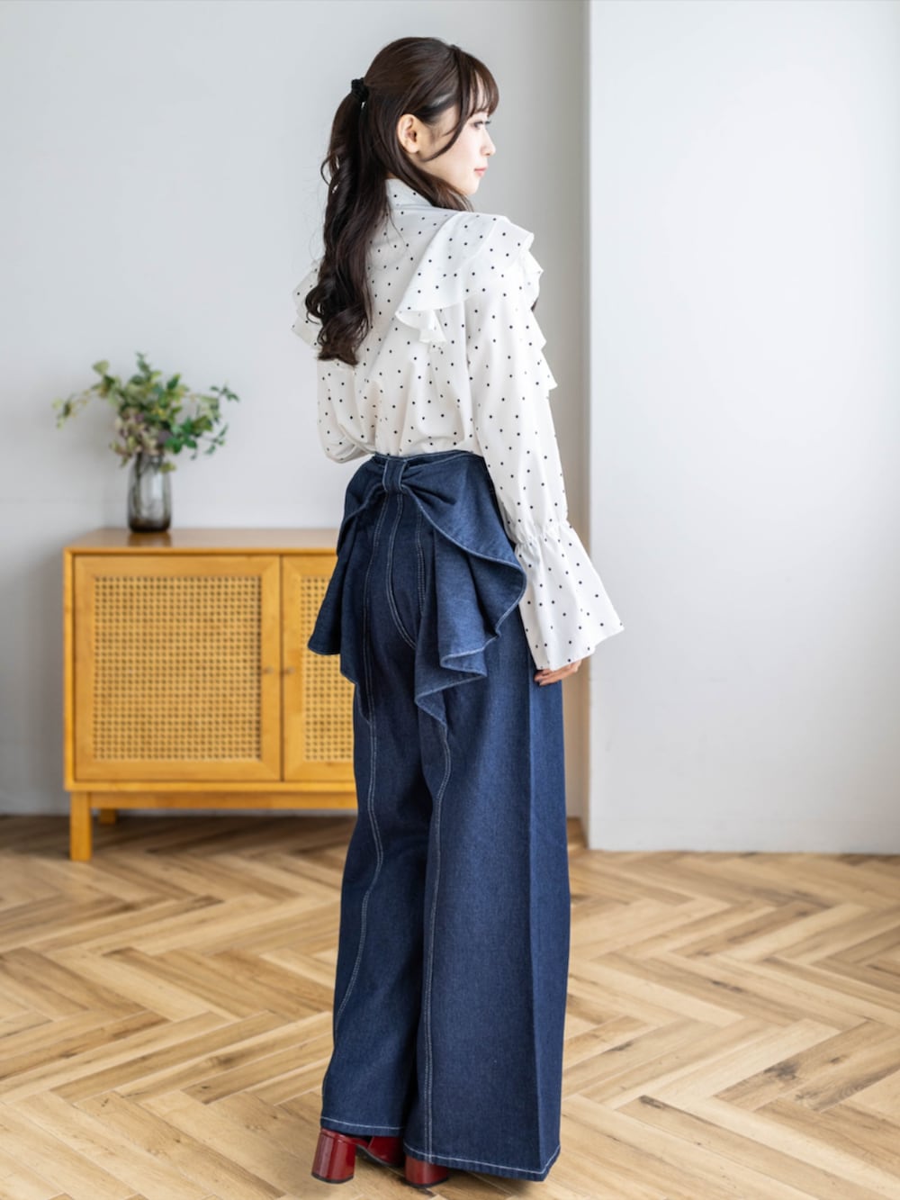 レッド系のパンプス、ホワイト系のシャツ/ブラウス、ブルー系のデニムパンツを着用したレディースの夏コーディネートの2枚目の写真