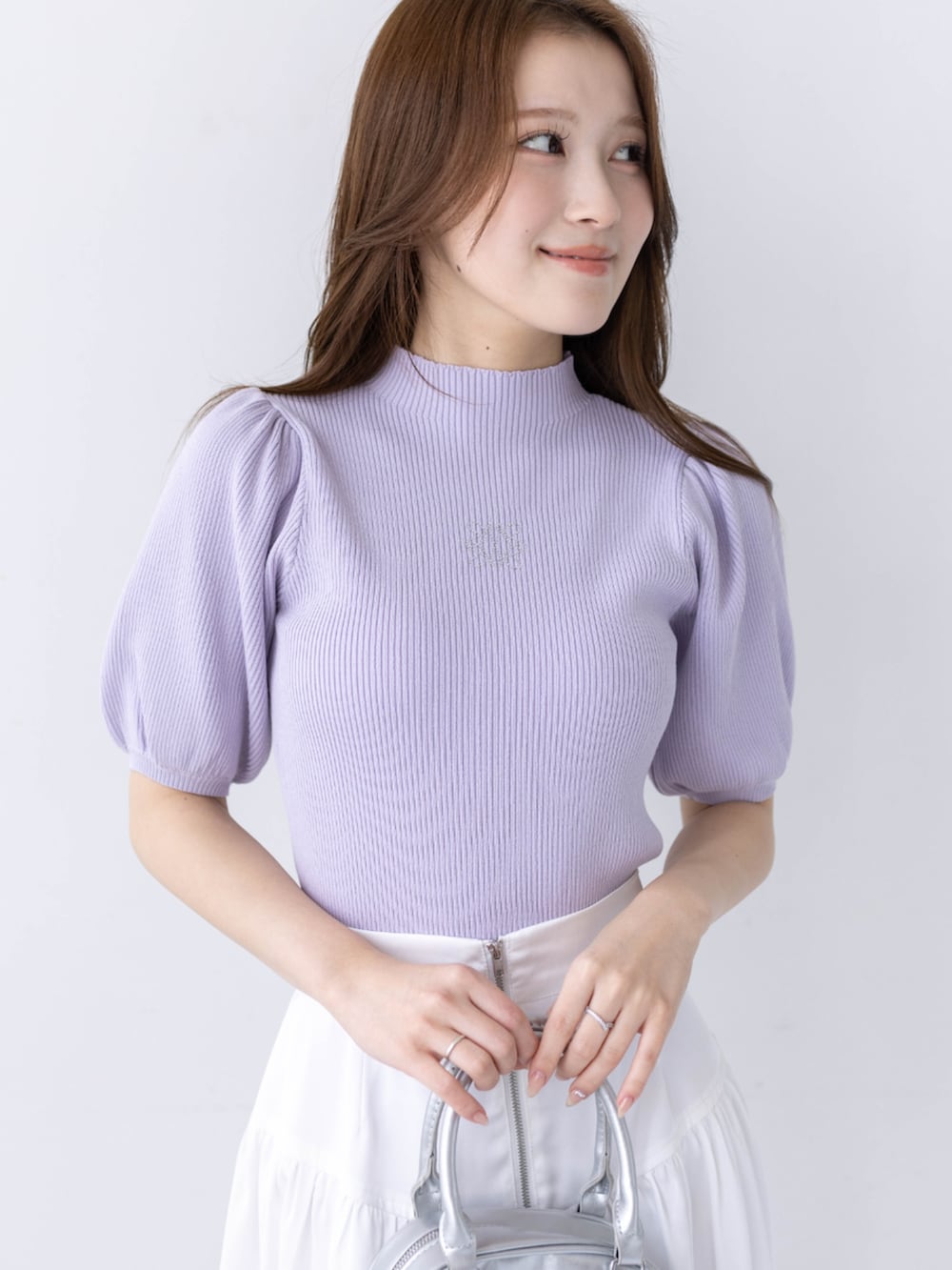 ホワイト系のスカート、ホワイト系のパンプス、パープル系のニット/セーターを着用したレディースの春コーディネートの3枚目の写真