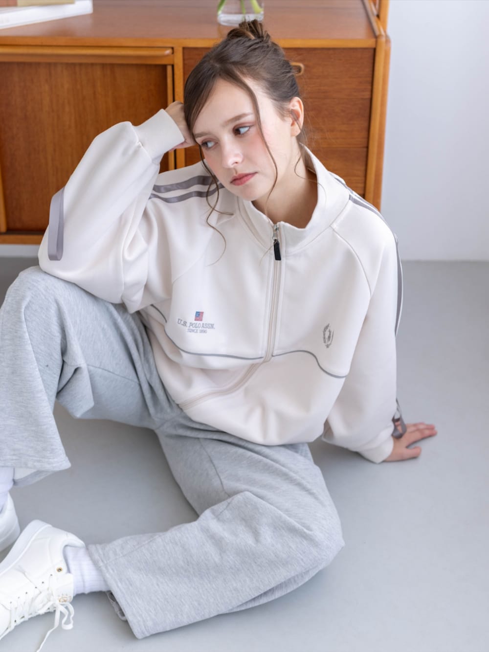 ゴールド系のスニーカー、グレー系のスウェットパンツ、ホワイト系のTシャツ/カットソーを着用したレディースの秋コーディネートの7枚目の写真