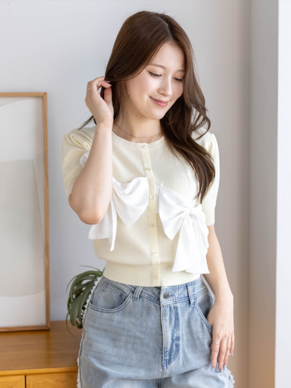 ブルー系のデニムパンツ、ホワイト系のパンプス、イエロー系のニット/セーターを着用したレディースの夏コーディネートの5枚目の写真