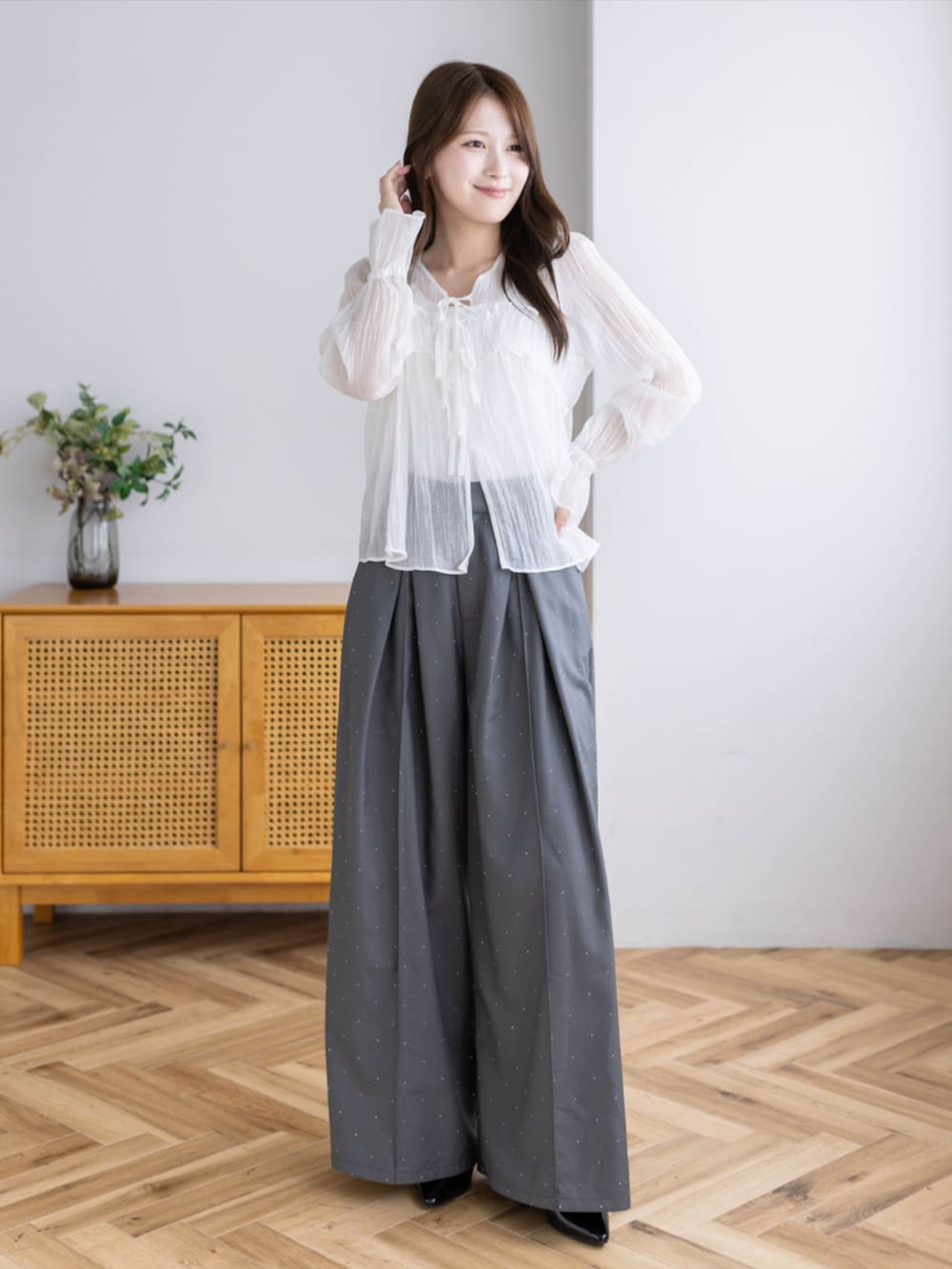 ブラック系のパンプス、グレー系のその他パンツ、ホワイト系のシャツ/ブラウスを着用したレディースの夏コーディネートの2枚目の写真