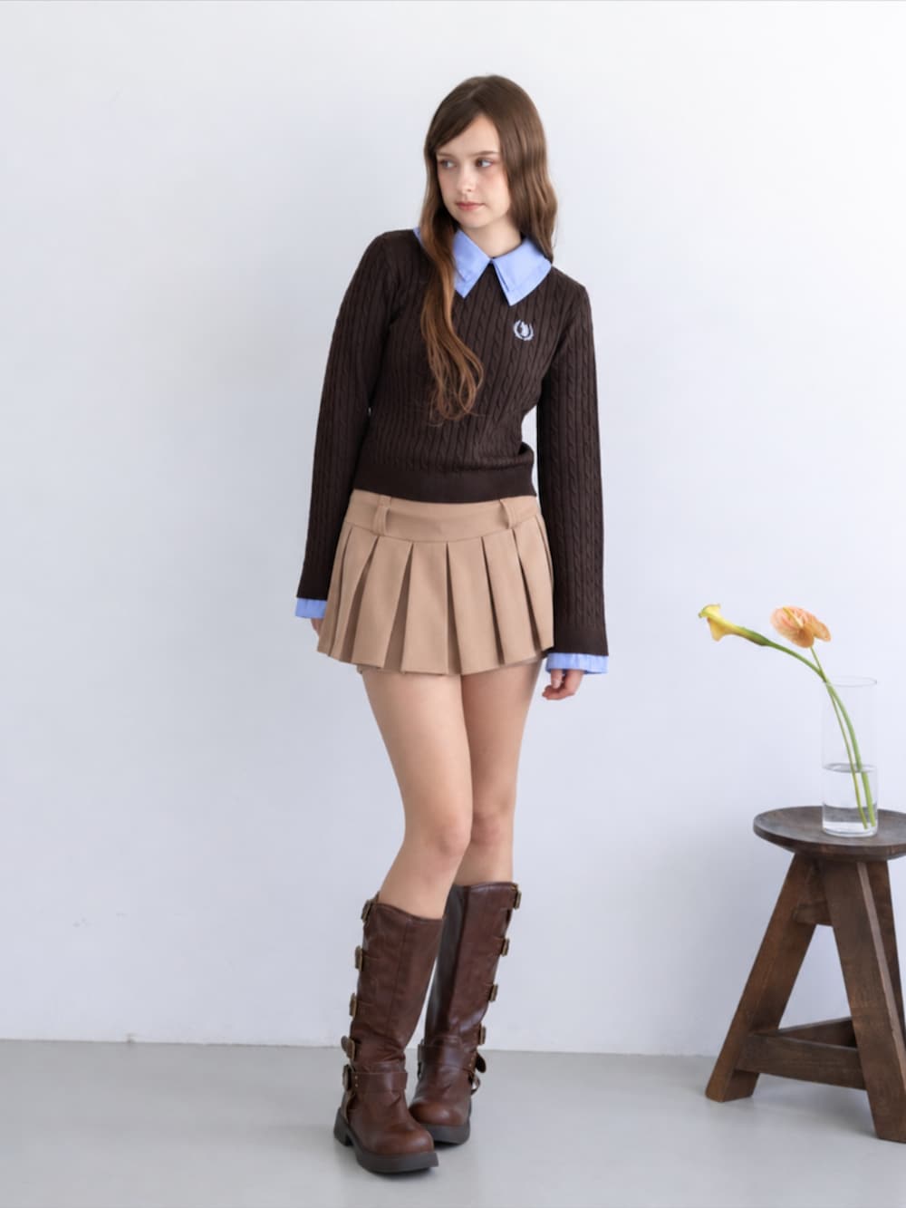 ブラウン系のブーツ、ベージュ系のスカート、ブラウン系のニット/セーターを着用したレディースの秋コーディネートの2枚目の写真