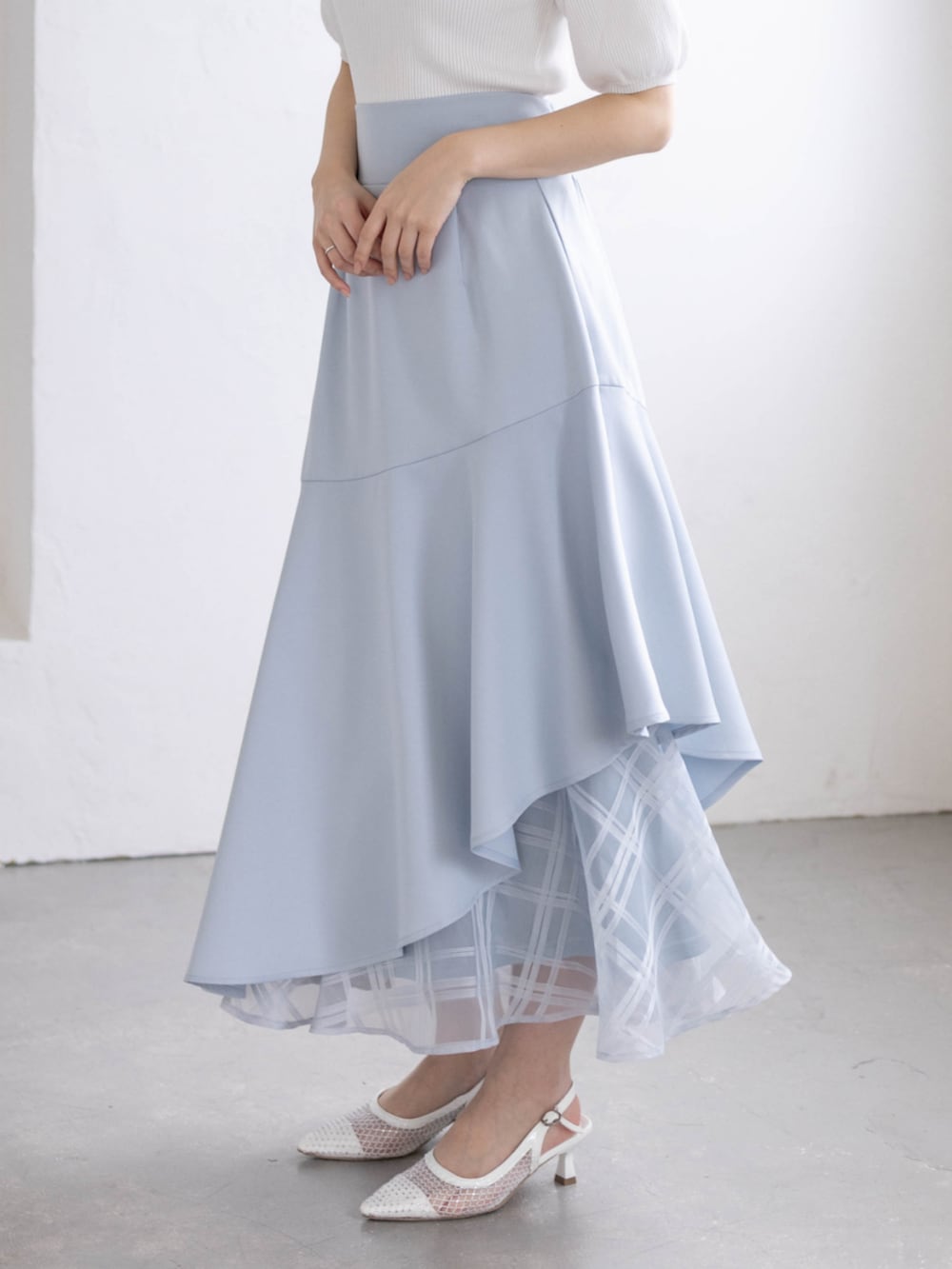 ホワイト系のパンプス、ブルー系のスカート、ホワイト系のニット/セーターを着用したレディースの春コーディネートの7枚目の写真