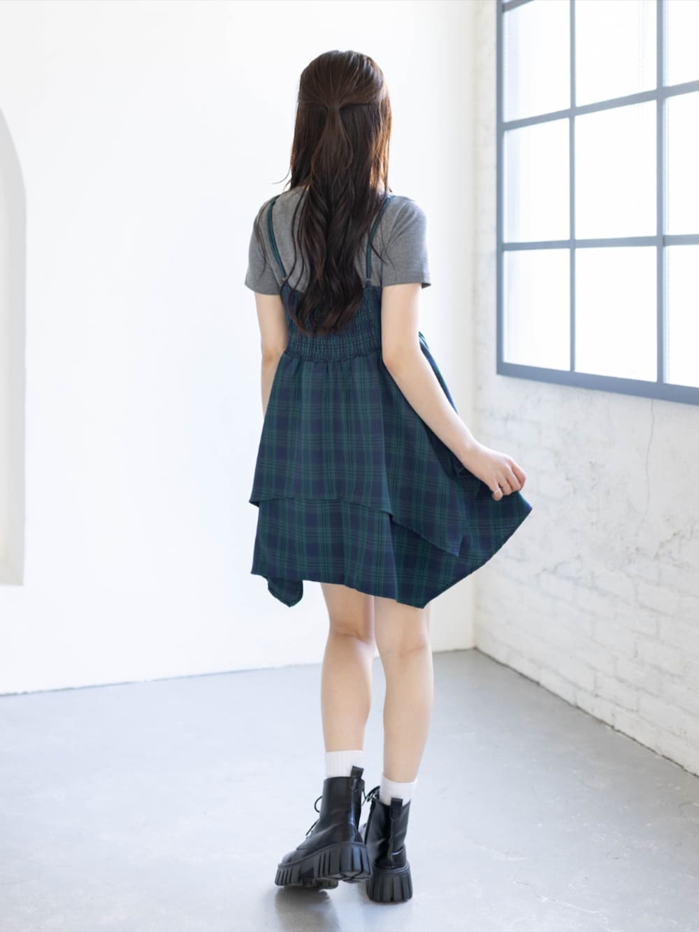 グリーン系のワンピース、ブラック系のブーツ、グレー系のTシャツ/カットソーを着用したレディースの夏コーディネートの2枚目の写真