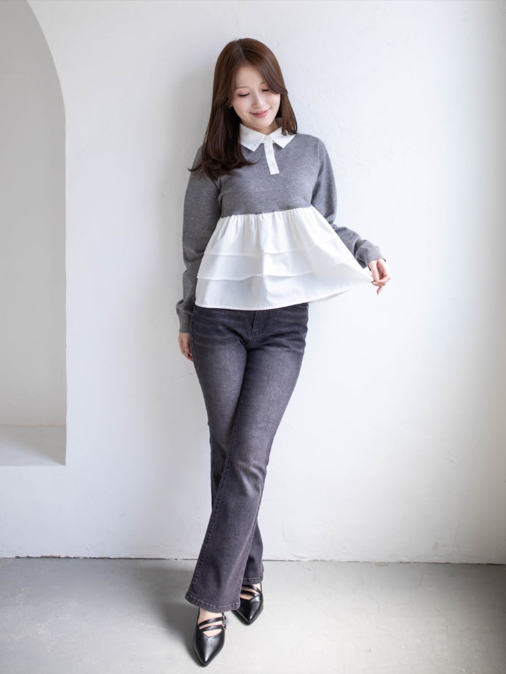 ブラック系のデニムパンツ、ブラック系のパンプス、グレー系のニット/セーターを着用したレディースの秋コーディネートの2枚目の写真