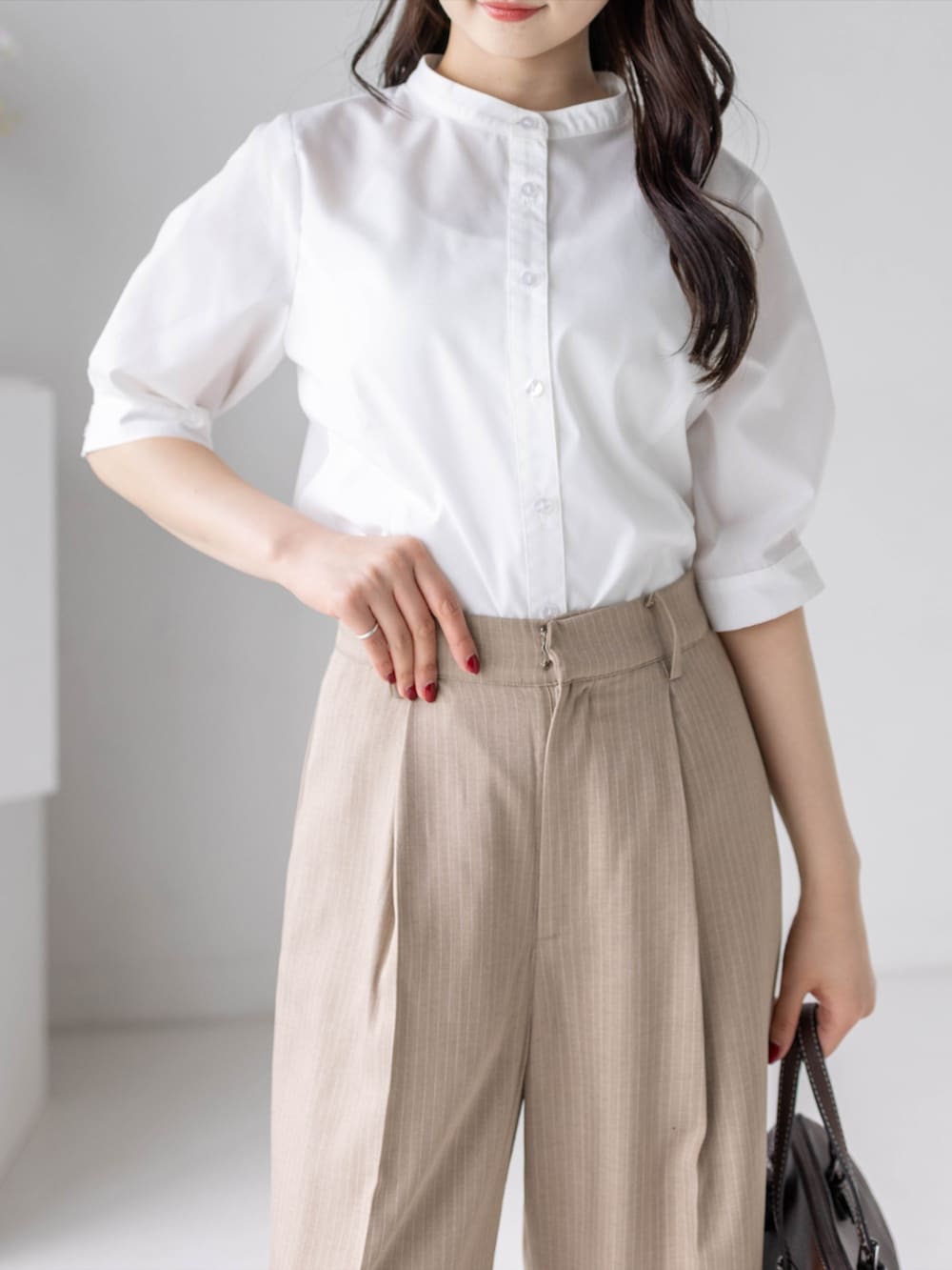 ベージュ系のスラックス、ホワイト系のパンプス、ホワイト系のシャツ/ブラウスを着用したレディースの夏コーディネートの7枚目の写真