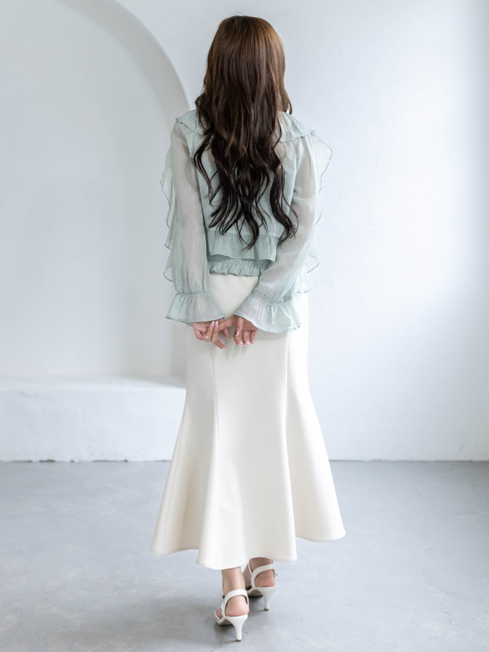 ホワイト系のスカート、ホワイト系のパンプス、グリーン系のシャツ/ブラウスを着用したレディースの春コーディネートの2枚目の写真