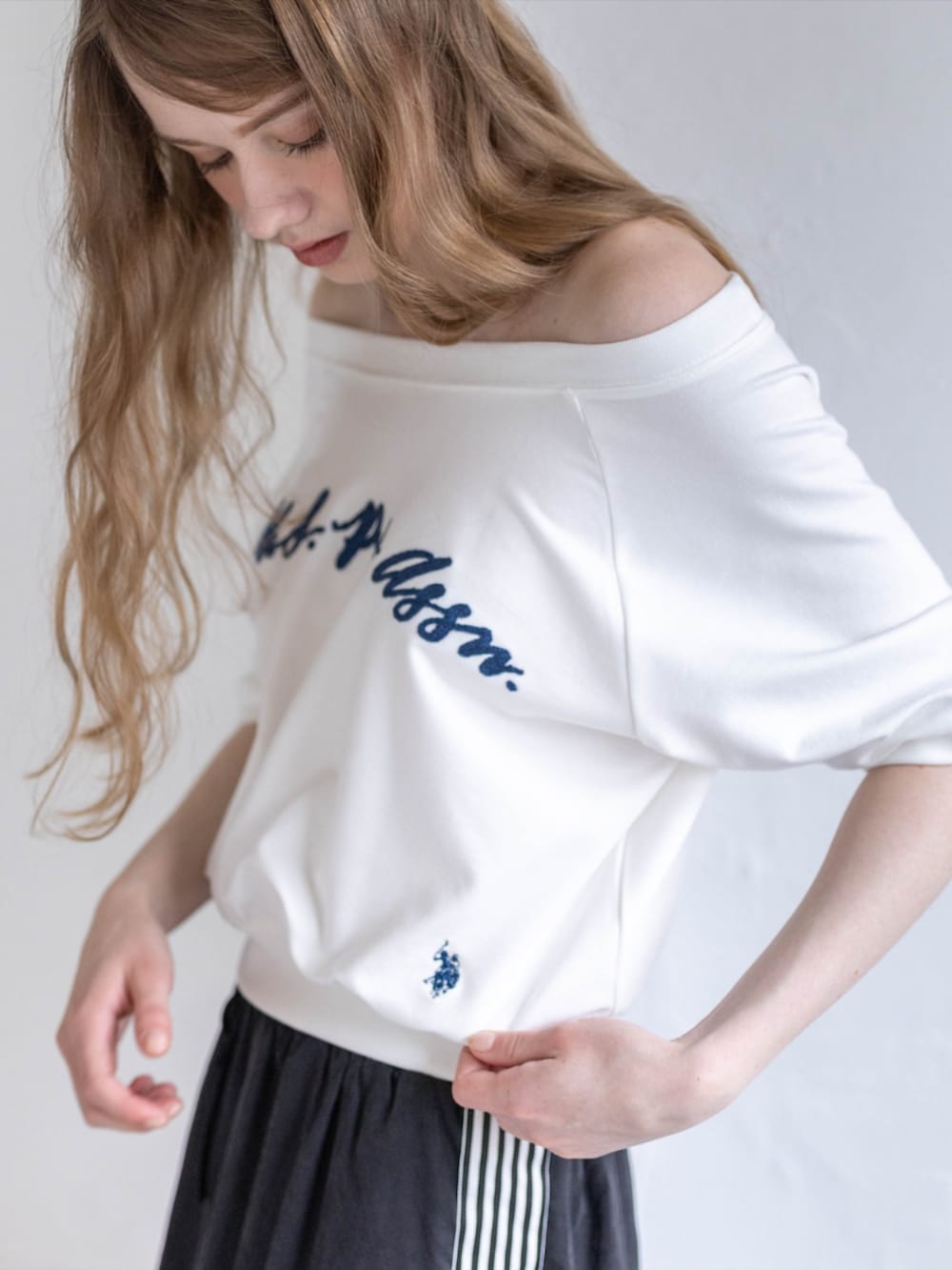 ブラック系のスニーカー、ブラック系のスカート、ホワイト系のTシャツ/カットソーを着用したレディースの夏コーディネートの5枚目の写真