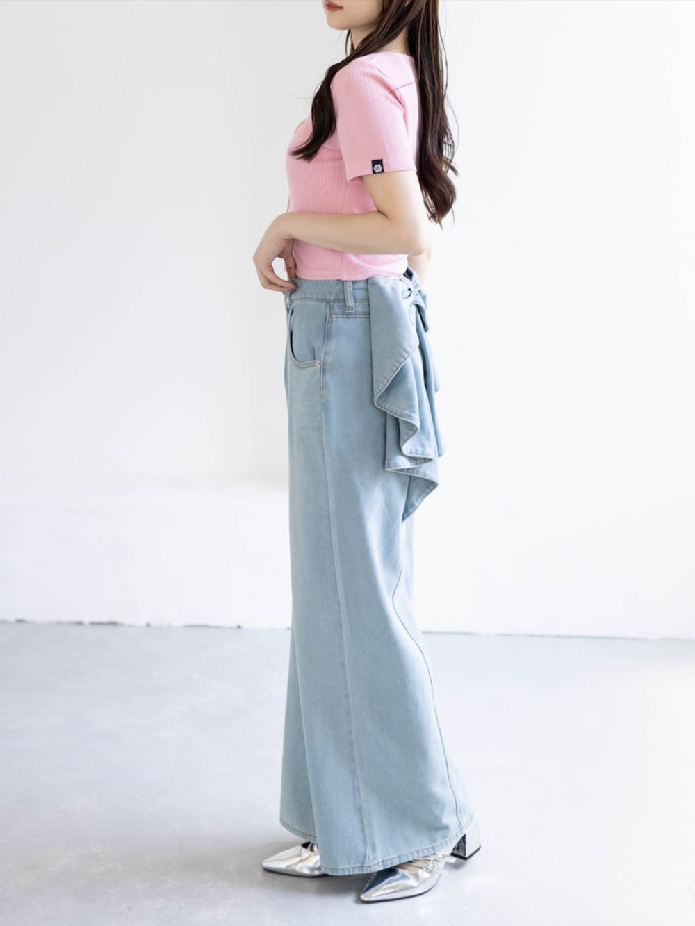 シルバー系のパンプス、ピンク系のTシャツ/カットソー、ブルー系のデニムパンツを着用したレディースの夏コーディネートの2枚目の写真