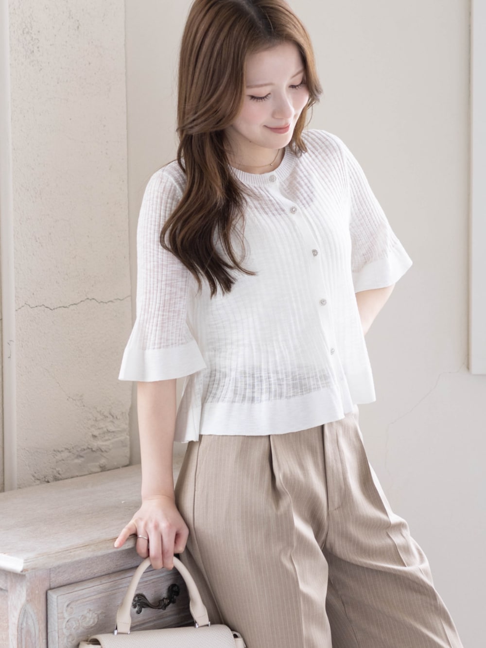 ベージュ系のスラックス、ホワイト系のパンプス、ホワイト系のカーディガン/ボレロを着用したレディースの春コーディネートの7枚目の写真