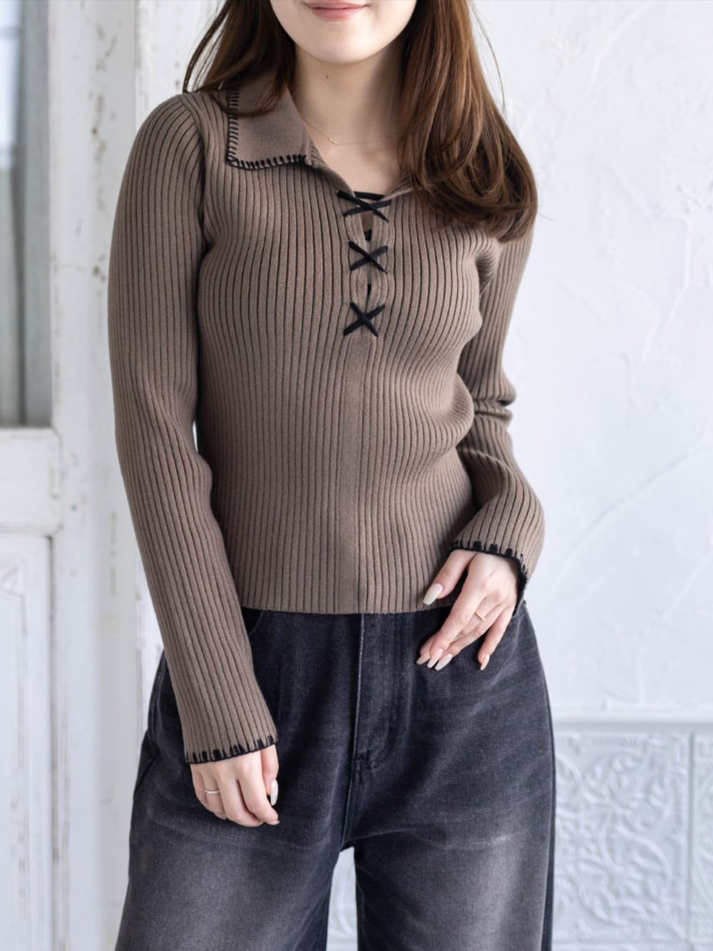 ブラック系のデニムパンツ、ブラック系のブーツ、ブラウン系のニット/セーターを着用したレディースの秋コーディネートの4枚目の写真