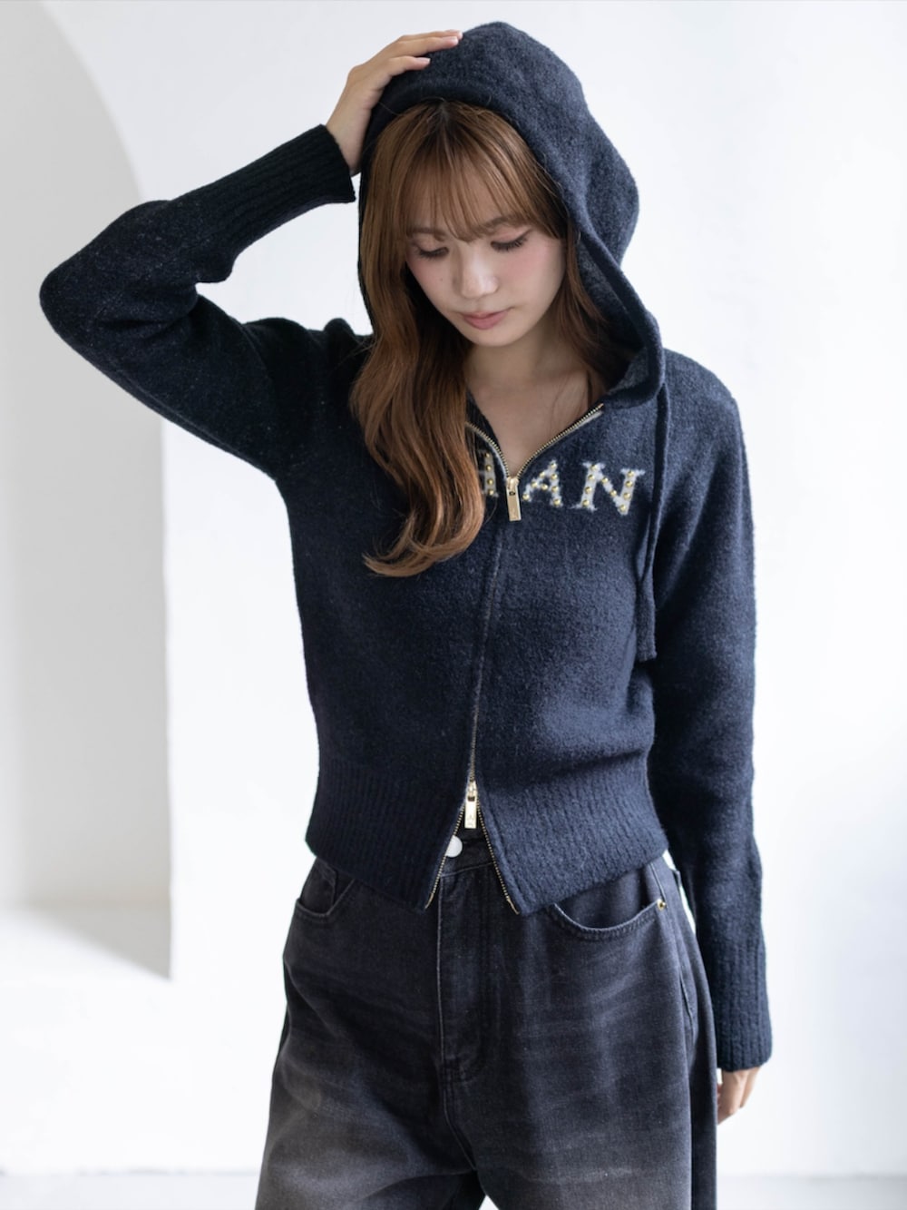 ブラック系のデニムパンツ、ブラック系のブーツ、ブラック系のニット/セーターを着用したレディースの秋コーディネートの7枚目の写真